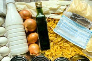 A large set of different food products, with a medical protective mask and antiseptic.