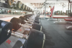 Close up many metal dumbbells on rack in sport fitness center