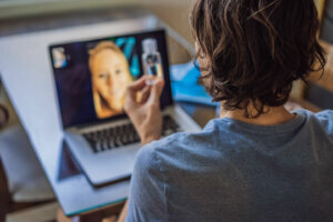 Coronavirus. Man in quarantine for coronavirus wearing protective mask. She's working from home and using video call. Video conference