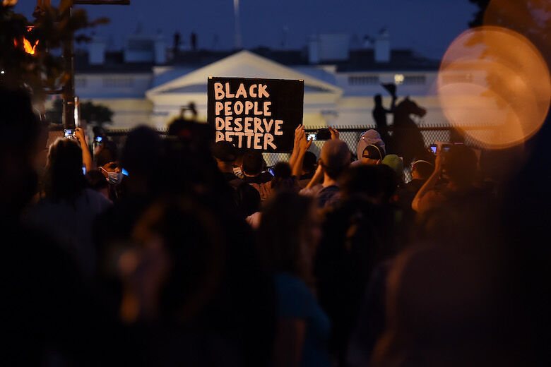 Demonstrators protesting the death of George Floyd hold up placards near Lafayette park accross the White House on June 2, 2020 in Washington, DC. - Anti-racism protests have put several US cities under curfew to suppress rioting, following the death of George Floyd in police custody. (Photo by Olivier DOULIERY / AFP) (Photo by OLIVIER DOULIERY/AFP via Getty Images)
