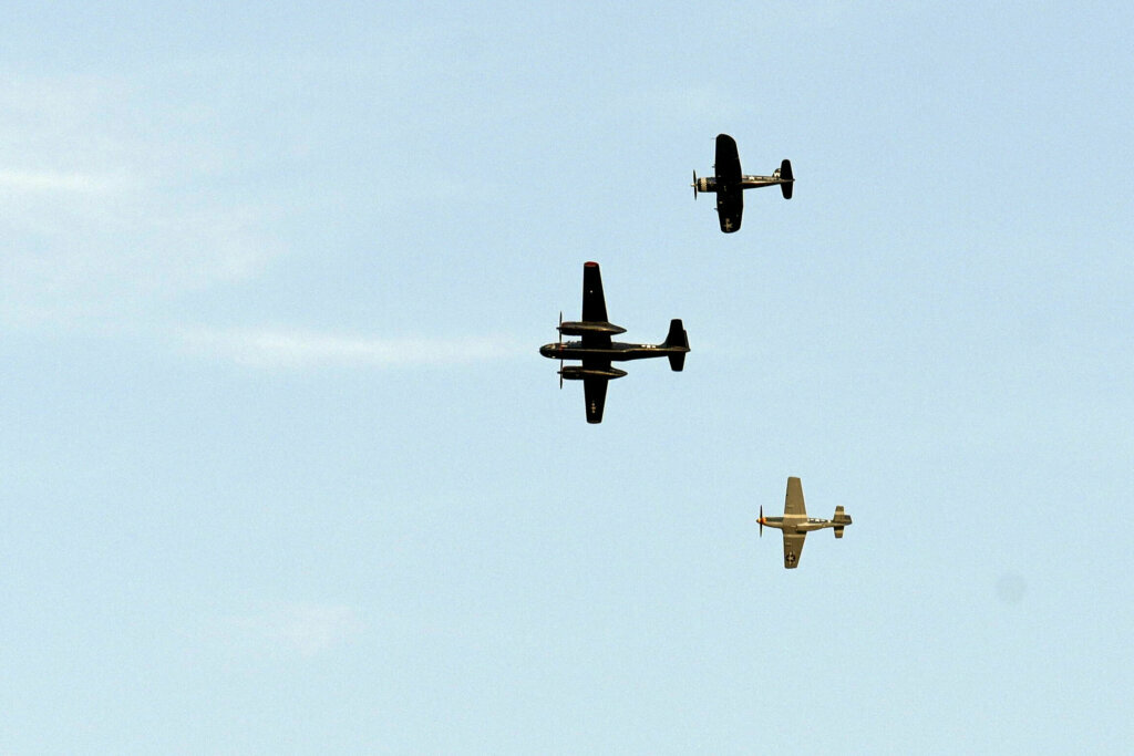 World War II military aircraft fly over the National Mall