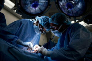 Dr. Niraj Desai (L) sews in a kidney to