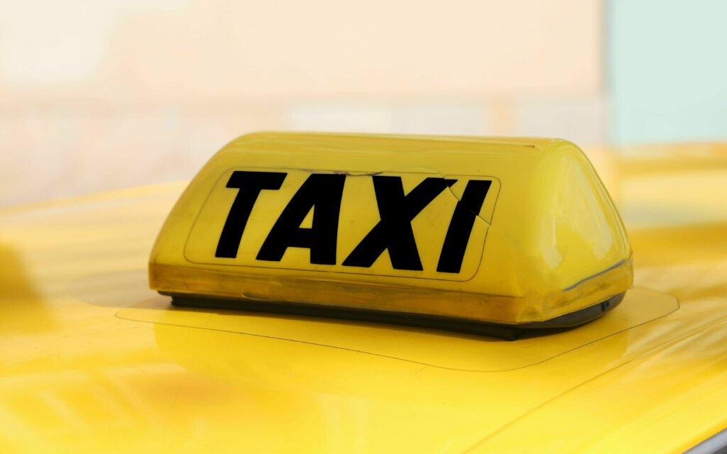 Writting taxi in black on a yellow taxi