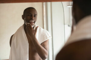African American man apply balm shaving in bath