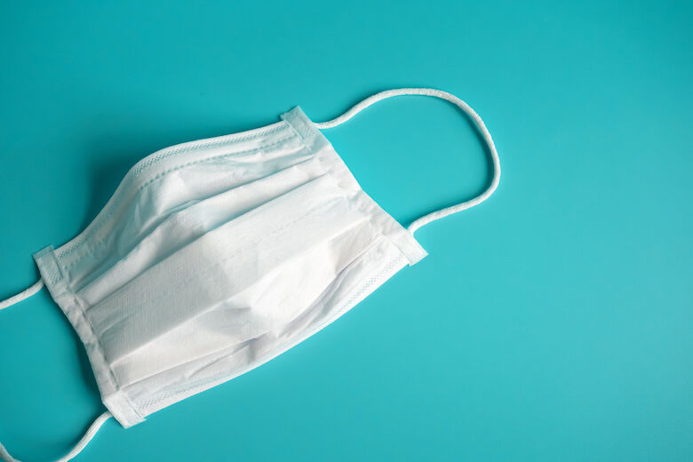 Close up white surgical face mask on blue green background , the equipment mask to protect man health from flu , coronavirus infection , Health care concept