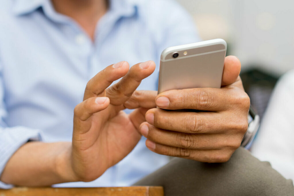 Close up mature businessman holding smartphone and checking news from company by texting to employee , business and technology concept