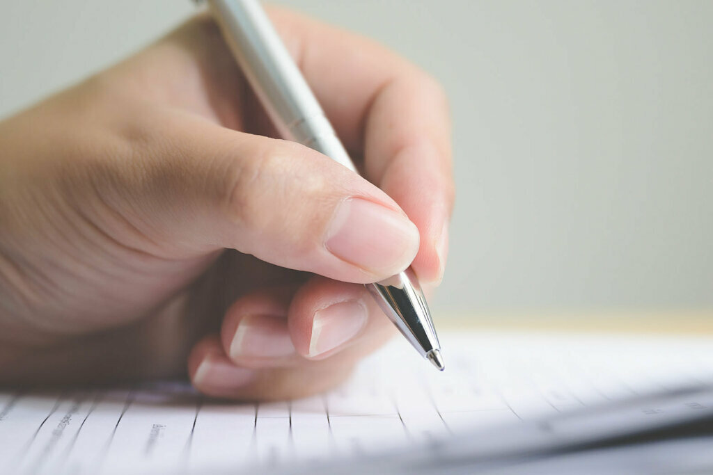 Hand of man signing signature filling in application form document business contract agreement