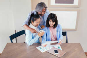 Happy Asian family reading and receiving a good news letter together at home, Information may contain tax refund money, university admission, lottery winning, test results or invitation letter