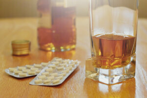 Pills and alcohol on the table, dependency concept