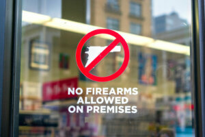 No firearms allowed on premises sign on the glass entrance door to establishment notifies patrons that weapons aren't allowed.