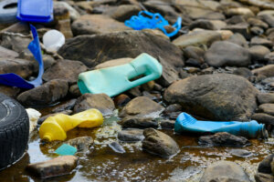 Dirty water with plastic waste tire on ocean beach