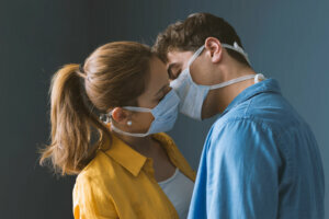 Young couple wearing a protective face mask and kissing