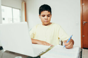 Distance learning online education. A boy studies at home and does school homework. A home distance learning.