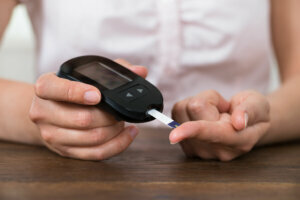 Person Hands Holding Glucometer