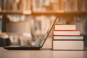 Bookshelves and laptops are placed on the library desk.E learning class and e book digital technology