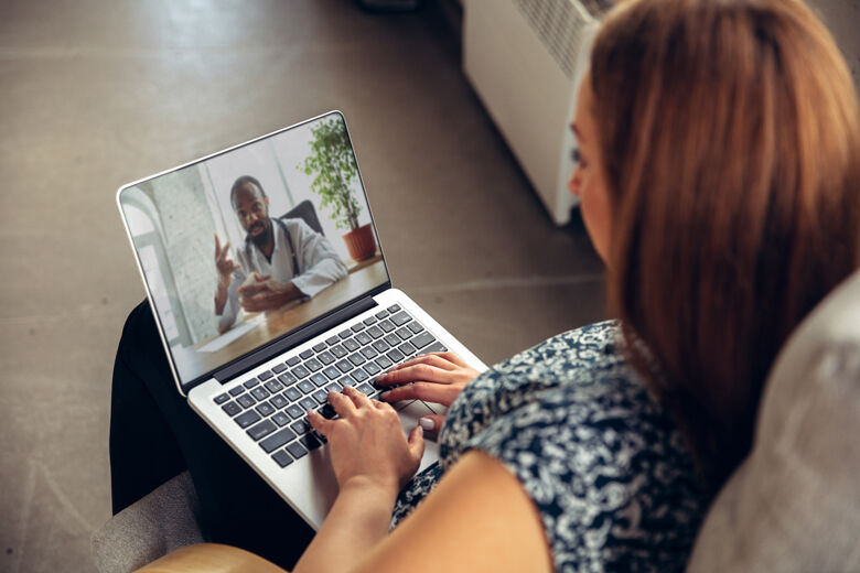 Close up of young woman getting online medical help and advice during videocall with doctor checking symtoms aand explaining the drug's reciepes