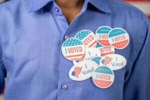 Close up of multiple I Voted stickers on blue shirt Concept of US election voter fraud by placing multiple voting stickers