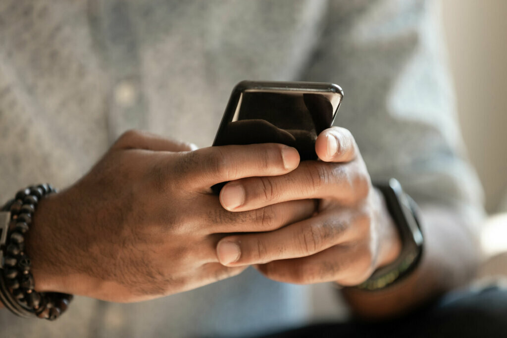 Man holding cellphone using applications, close up view