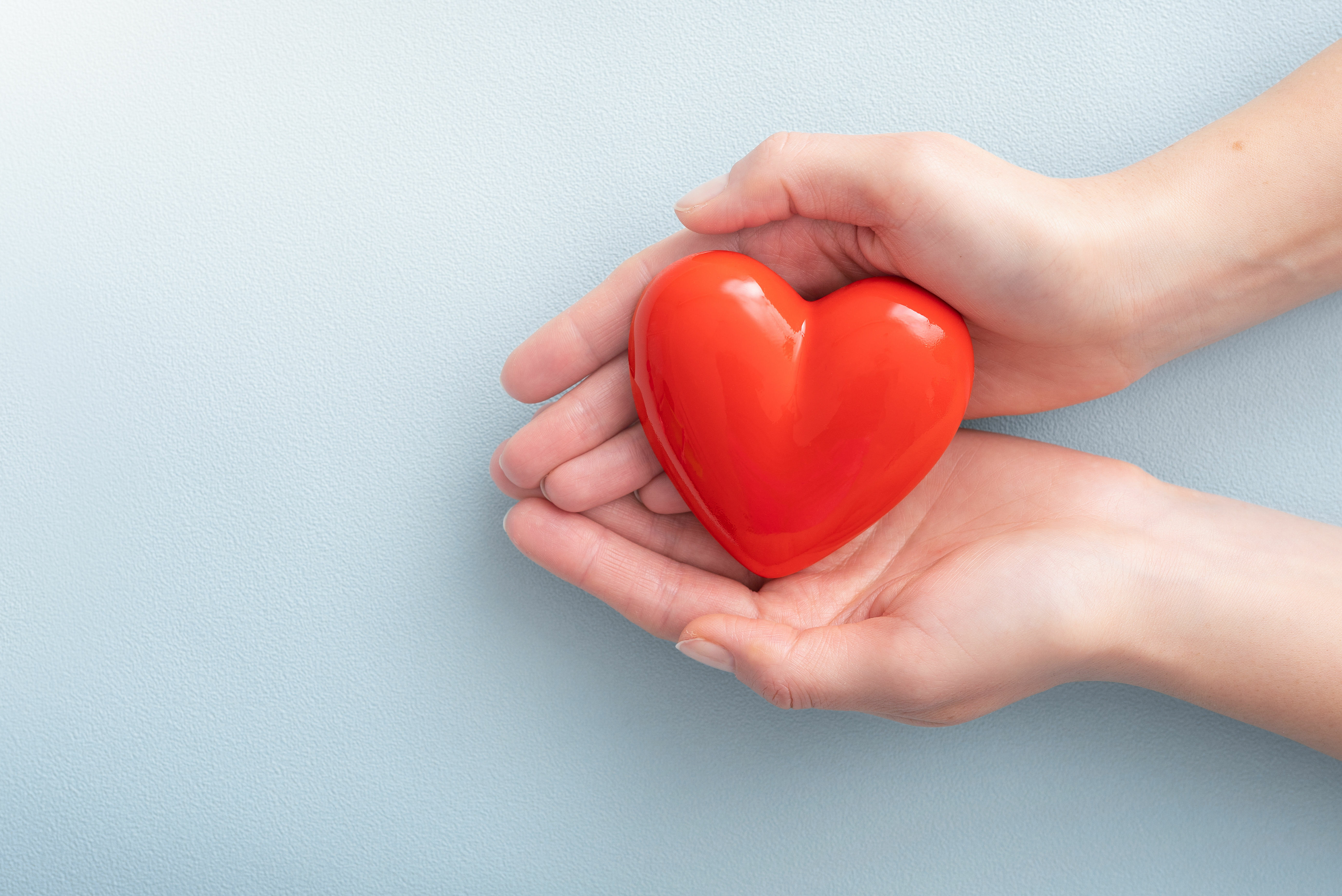 The woman is holding a red heart.