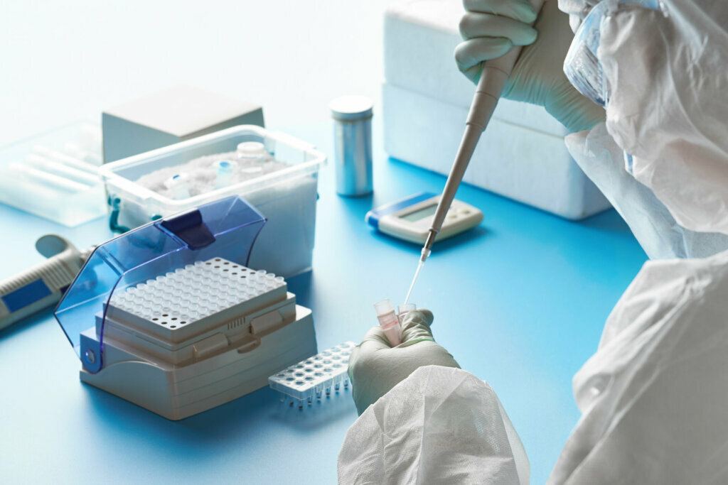 SARS COV 2 pcr diagnostics kit. Epidemiologist in protective suit, mask and glasses works with patient swabs to detect specific region of 2019 nCoV virus causing Covid 19 viral pneumonia.