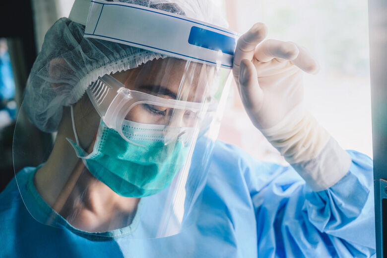 Nurse having headache and tired from work while wearing PPE suit for protect coronavirus disease.
