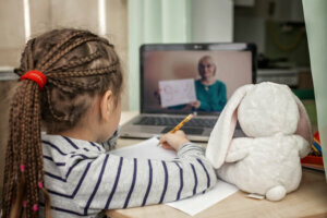 Pretty stylish schoolgirl studying math during her online lesson at home, self isolation