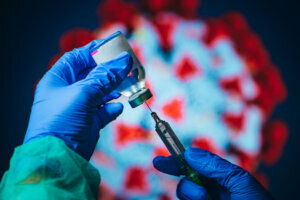 Coronavirus Covid 19 Protection and Vaccine. Doctor drawing up solution from vaccine bottle and filling syringe injection for patient vaccination in medical clinic, Coronavirus in background