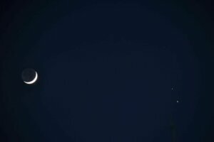 A crescent moon along with Saturn (upper right) and Jupiter