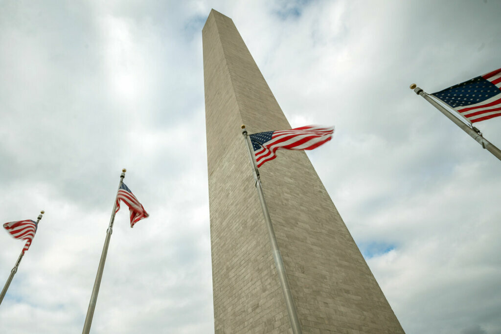 Washington Monument with clouds and American Flags in D.C.