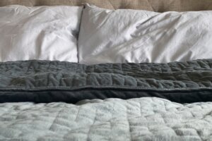 Still life of gray, weighted, blanket in bedroom
