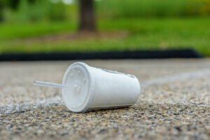 Paper cup and plastic straw litter on street