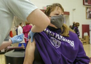 Stephanie McQuillan, a 1st grade teacher at Tyler Elementary in Gainsville, gets her first COVID 19 vaccination at Unity Reed High School in Manassas.
