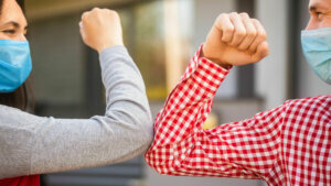 Couple,Greeting,With,Elbows.,Elbows,Bump.,Friends,In,Protective,Medical