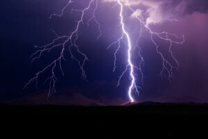 Lightning bolt strikes a mountain during a storm.