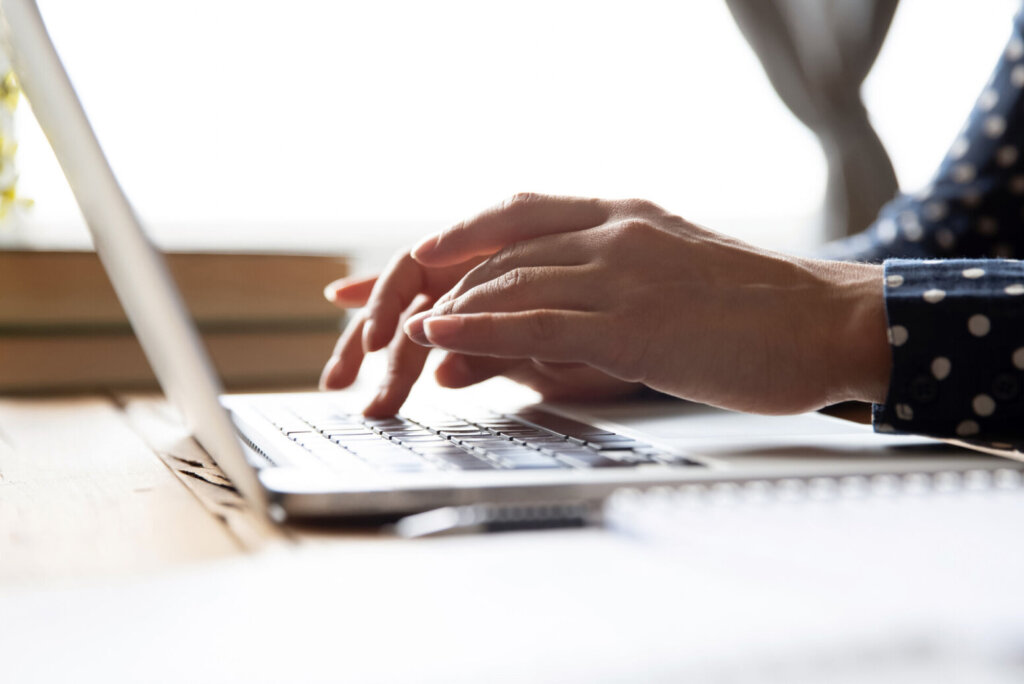 Female professional student using laptop at desk, close up view
