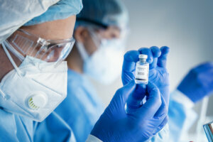 Coronavirus covid 19 vaccine bottle in hands of pharmacuetical and vaccine research scientist in laboratory, coronavirus covid 19 vaccine development
