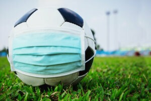 Soccer ball with medical mask in the empty stadium. covid 19 spreading outbreak