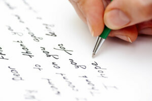 Woman hand with pen writing letter to the friend. Close up.
