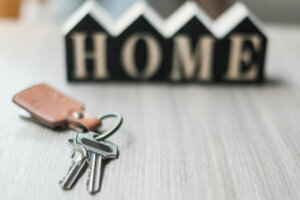 Key and wooden Home model on table office. New House, Financial, Property insurance and real estate concepts