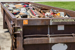 Garbage, trash or waste dumpster full of household junk. Concept of cleaning, cleanup, hoarding and disposal.