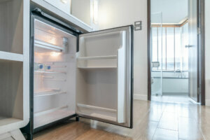 Opened small refrigerator under the counter and in front of toilet in delux room at resort and hotel.