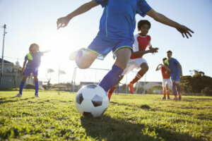 Close up of boy kicking soccer ball
