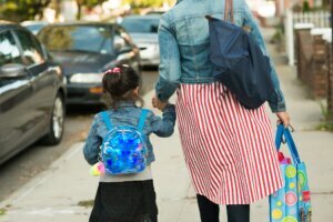 Muslim mother in hijab taking daughter to school