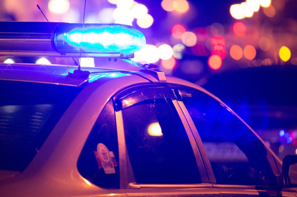 Blue,Light,Flasher,Atop,Of,A,Police,Car.,City,Lights