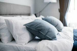 Bed maid up with clean white pillows and bed sheets in beauty room. Close up. Lens flair in sunlight.