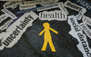 Paper man surrounded by Corona Virus and economic news headlines