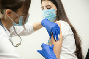 Close up doctor or nurse giving vaccine to patient using the syringe injected in hospital