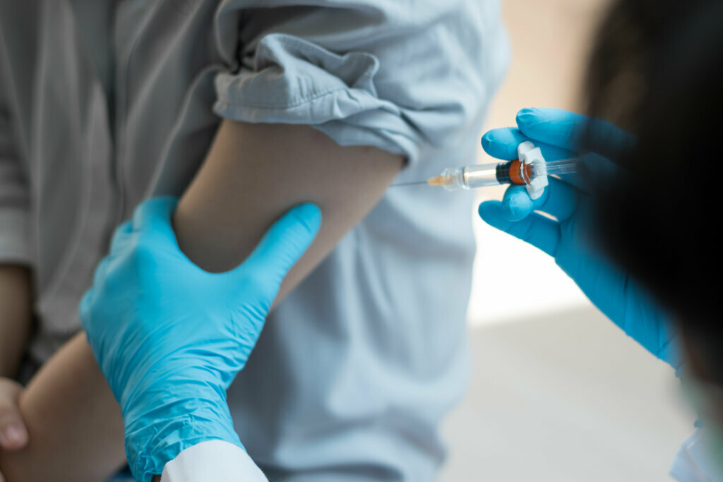 Covid 19 vaccine concept. Hand of doctor in medical gloves with syringe and vaccination bottle in hospital laboratory for new coronavirus disease