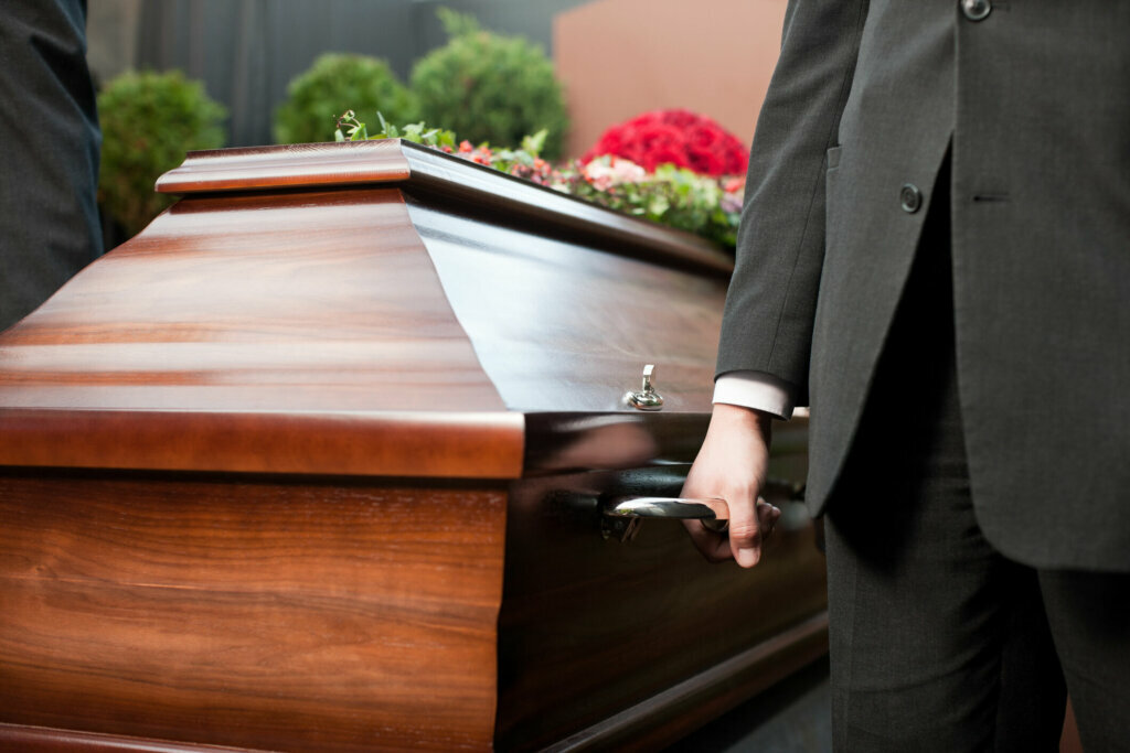 Funeral with casket carried by coffin bearer