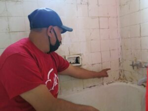 Erwin Rodas, a Bedford Station resident and plaintiff in a lawsuit challenging conditions at the property, says his bathroom is in bad shape and needs repair. Photo by Rosanne Skirble.